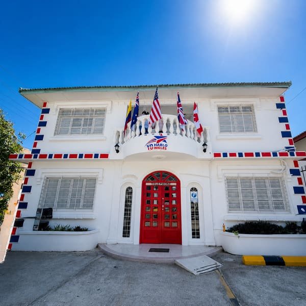 Fachada de la sede de Yo Hablo Inglés en Barranquilla, con banderas y puerta roja